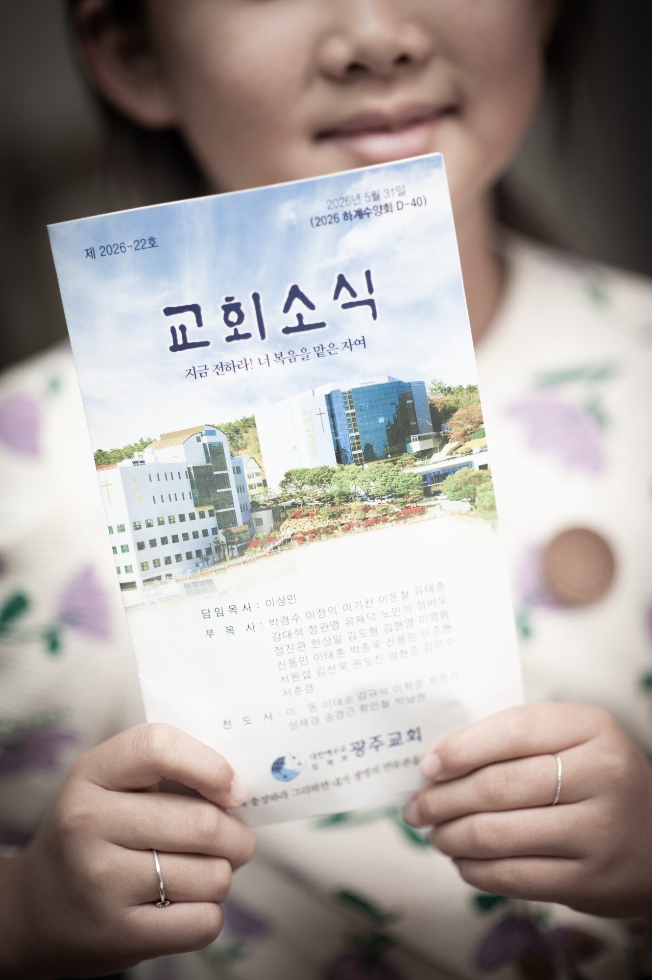 교회 소식지를 들고 있는 아이